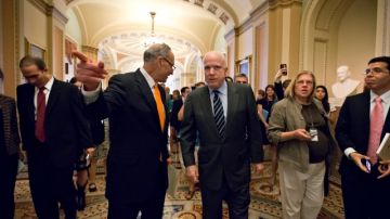 Los senadores Charles Schumer (D-NY) y John McCain (R-AZ) en los pasillos del Capitolio, luego de la aprobación del proyecto de reforma migratoria por parte del  Senado.