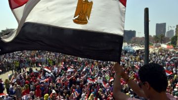 Un manifestante egipcio ondea una bandera nacional durante una concentración en la plaza Tahrir, de El Cairo (Egipto).