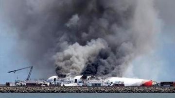 Bomberos tratan de sofocar las llamas y el humo de un Boeing 777 de Asiana Airlines después de estrellarse en el aeropuerto internacional de San Francisco.