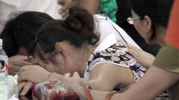 Los padres de Wang Linjia, una de las víctimas, lloran en medio de la conferencia de prensa  ayer para ofrecer detalles del accidente.