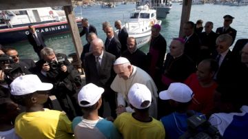 El papa Francisco (cen.) conversa con varios inmigrantes durante su visita a la isla de Lampedusa (Italia), ayer.
