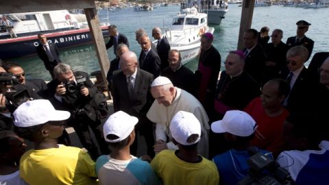 El papa Francisco (cen.) conversa con varios inmigrantes durante su visita a la isla de Lampedusa (Italia), ayer.