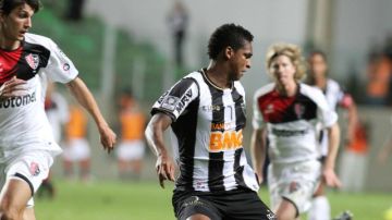 El jugador de Atlético Mineiro Jo (d) recibe el balón ante la marca de Santiago Vergini (i), de Newell's Old Boys