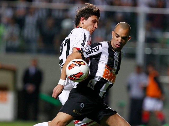 Diego Tardelli, de Atlético Mineiro, disputa el esférico con Santiago Vergini, de Newell's Old Boys