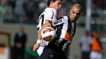 Diego Tardelli, de Atlético Mineiro, disputa el esférico con Santiago Vergini, de Newell's Old Boys