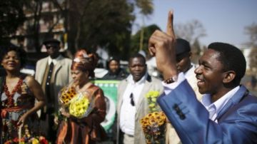 Sudafricanos cantan y rezan a las afueras del hospital de Pretoria donde el expresidente sudafricano Nelson Mandela permanece ingresado desde el pasado 8 de junio.