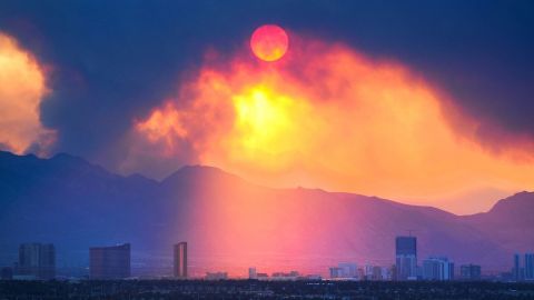 El sol sale entre el denso humo que cubre el cielo de la famosa calle de los casinos en Las Vegas, debido a un gran incendio que está devorando un área cercana a la ciudad.