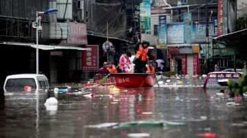 Fuerzas paramilitares chinas usan un bote para evacuar a las víctimas de las inundaciones.