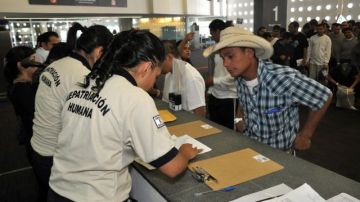 Ciudadanos mexicanos deportados de los EEUU son procesados y ayudados por agentes pertenecientes a Instituto Nacional de Migración de México (INAMI) a su llegada al aeropuerto de Ciudad de México.