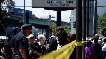 Una multitud se reúne cerca de las calle Ocho y Brannan  después de un tiroteo en San Francisco. Dos mujeres murieron y un hombre resultó herido el viernes en el ataque.
