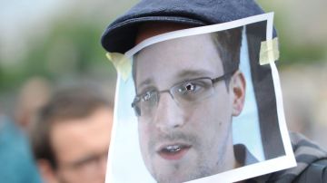 Un simpatizante del exempleado de la CIA Edward Snowden luciendo una careta con el rostro del exagente durante una manifestación en Berlín.