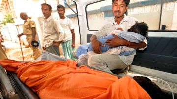 Un hombre llora dentro de una ambulancia mientras sostiene el cuerpo de su hija muerta, a su llegada al hospital en Patna.
