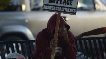 Un manifestante sentado en el parque Leimert, en la avenida Crenshaw, mientras participa en un encuentro de oración tras conocerse el veredicto que absolvió a Zimmerman de la muerte de Trayvon Martin, en Los Ágeles.
