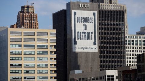 Un letrero de  'Outsource to Detroit' de  Galaxe.Solutions es desplegado en un edificio. La ciudad busca declararse en bancarrota.