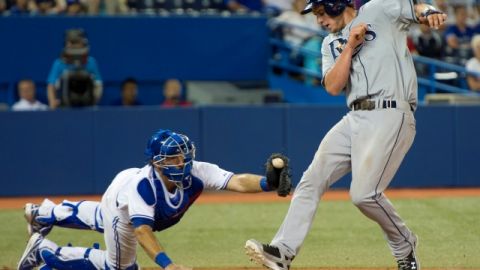 Will Myers elude el guante del receptor de Toronto,  J.P. Arencibia, para anotar en el juego de ayer ante los Azulejos.