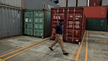 Un agente panameño pasa al lado de contenedores con armas de Cuba abordo del barco norcoreano Chong Chon Gang.