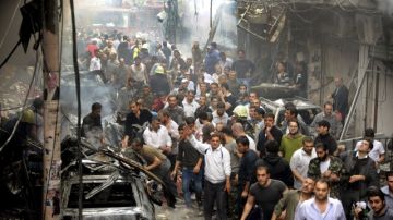 Decenas de civiles buscan víctimas de entre los escombros, después de producirse un atentado suicida de un coche-bomba, en Damasco. La violencia en Siria parece no tener solución.