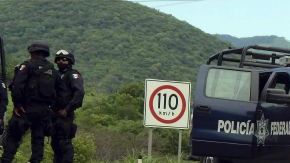 Agentes federales y soldados del Ejército mexicano resguardan una carretera en el municipio de Arteaga, en el estado mexicano de Michoacán, donde se registró uno de los varios ataques contra oficiales federales ocurridos en este estado.