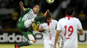 Juan Pablo Angel (i), de Nacional, disputa el balón con Daniel Carrico (c) del Sevilla, en juego de la  Copa Euroamericana.