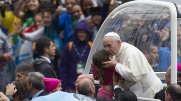 El papa Francisco besa a una niña a su llegada ayer a la catedral de Río de Janeiro donde oficiaría una misa.