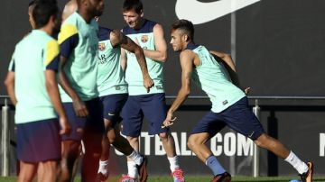 Neymar (der.) y su compañero Leo Messi (centro) se cruzaron ayer por primera vez en durante en el entrenamiento del Barcelona.