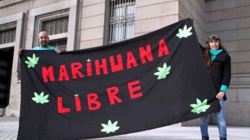 Dos personas se manifiestan a favor de la legalización de la mariguana en Montevideo.