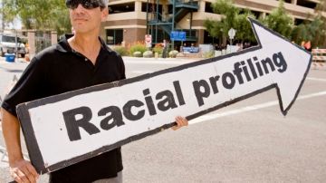 Un activista sostiene un cartel en referencia al perfil racial.