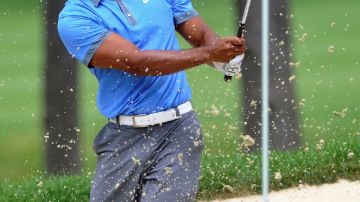 Tiger Woods observa la arena que sale del quinto hoyo al realizar un tiro en la segunda ronda del Torneo Invitacional WGC Bridgestone.