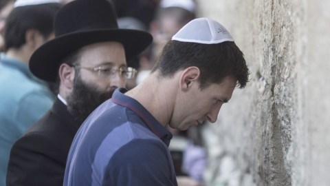 Lio Messi introduce el papelito con sus deseos en una de las grietas del  Muro de los Lamentos, ayer.