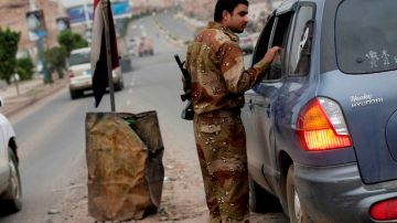Un soldado de Yemen inspecciona un vehículo en un punto de chequeo en la embajada de EEUU en Sanaa.