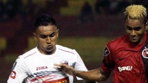 Fidel Martínez, de Xolos, intenta pasar entre dos rivales