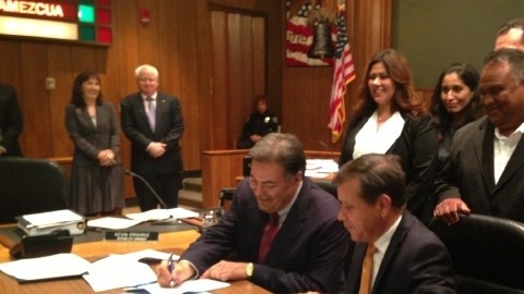 David Cavazos, nuevo administrador de la ciudad de Santa Ana, firma su contrato acompañado del alcalde Miguel Pulido.