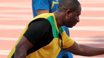 Usain Bolt (der.) recibe una palmada en la espalda de uno de sus compañeros durante la práctica de ayer.