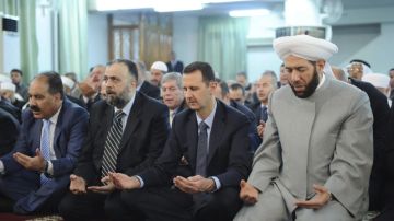 El presidente sirio Bachar al Asad (2 der.), durante el rezo de la Fiesta de la Ruptura o Eid al Fitr, ayer, en Damasco, Siria, mientras los rebeldes atacaban con morteros un elegante barrio de la capital.