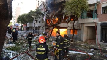 Bomberos a las afueras del edificio de 10 pisos en el que se registró una fuerte explosión en el centro de la ciudad de Rosario.