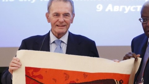 Jacques Rogge, presidente del COI (izq.), recibe un regalo  del presiden-te de la Federación Internacional de Atletismo, Lamine Diack.