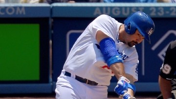 Adrián González golpea la bola para conectar un jonrón de dos carreras sobre el pitcher Roberto Hernández en la primera entrada.