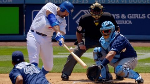 Adrián González golpea la bola para conectar un jonrón de dos carreras sobre el pitcher Roberto Hernández en la primera entrada.