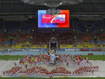 Deportistas participantes en el Mundial de Atletismo de Moscú, hacen su presentación junto a la mascota de la justa.