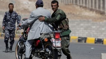 Soldados inspeccionan a un motociclista en Yemen en un retén en las calles que conducen a las embajadas de Estados Unidos y Gran Bretaña.