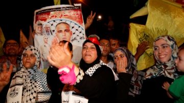 Familiares palestinos de Atif Shaat celebran mientras esperan su liberación en un punto de control  entre la Franja de Gaza e Israel.