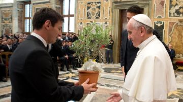 El Papa Francisco (c) recibe un árbol de olivo de manos del argentino  Lionel Messi (i), mientras el portero del combinado de Italia, Gianluigi Buffon (d), los observa.