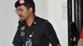 Policías malasios escoltan a José Regino Villareal (centro) y Luis Alfonso  González a su salida del  tribunal.