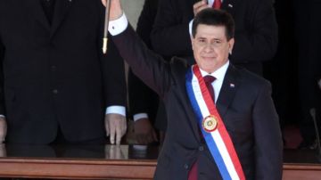 Horacio Cartes saluda tras jurar como nuevo mandatario de Paraguay, frente a la sede del Palacio de Gobierno en Asunción.