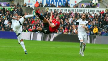Esta jugada acrobática del holandés  Robin Van Persie (centro)    va a terminar en el primer gol del Manchester United, frente al   Swansea City.