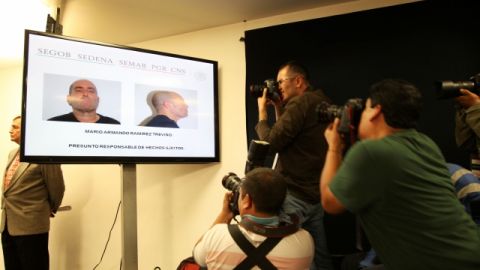 Periodistas toman fotos del narco líder del Cartel del Golfo, Mario Armando Ramírez Treviño durante el anuncio de su captura.