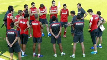 Jugadores del Atlético de Madrid atienden  indicaciones tácticas en la práctica previa al  juego de hoy.