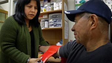 Laura López revisa la presión arterial de Santos Aguilar en una clínica de Oakland.