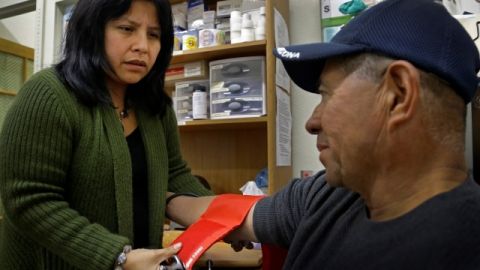 Laura López revisa la presión arterial de Santos Aguilar en una clínica de Oakland.