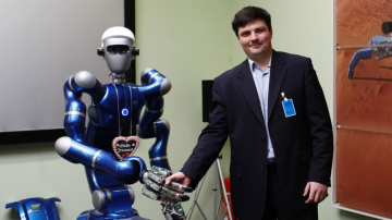'Justin' y el Profesor Vladimir Mulukha estrechan manos en la investigación de comunicación entre robots.